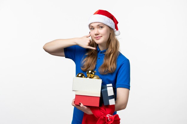 Vue de face du courrier féminin avec des jouets et des cadeaux sur un mur blanc