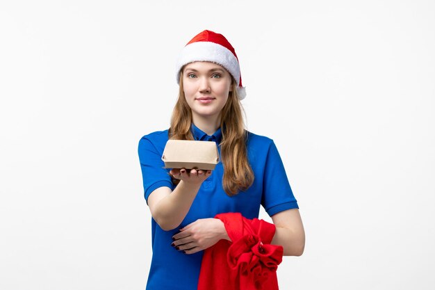 Vue de face du courrier féminin avec livraison de nourriture sur mur blanc