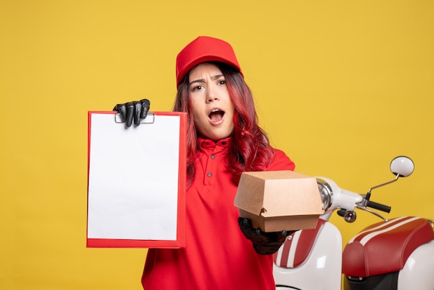 Vue de face du courrier féminin avec peu de paquet de nourriture sur mur jaune