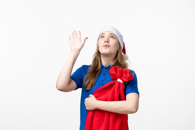 Vue de face du courrier féminin tenant le sac présent sur le mur blanc