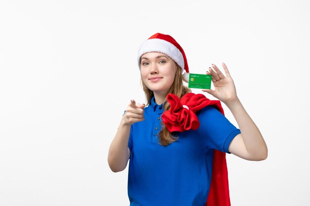 Vue de face du courrier de jeune femme tenant une carte bancaire sur un mur blanc