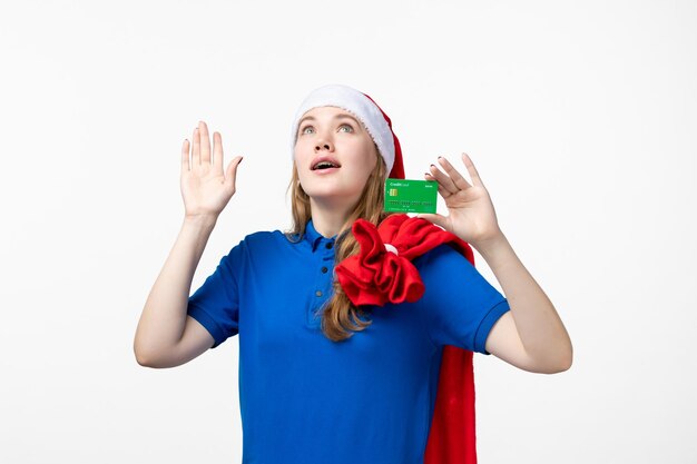 Vue de face du courrier de jeune femme tenant une carte bancaire sur un mur blanc