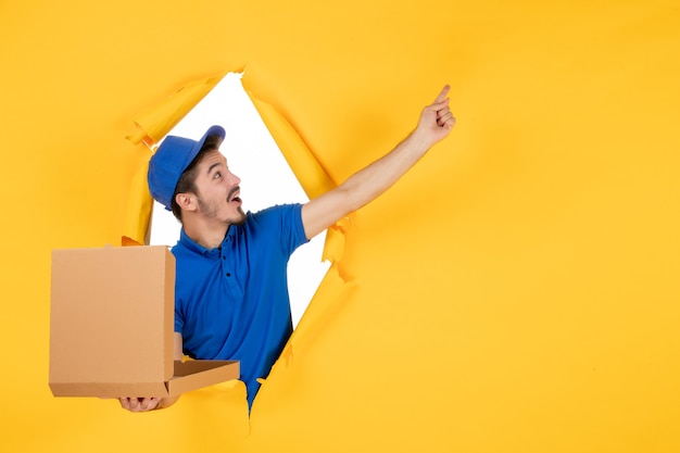 Photo gratuite vue de face du courrier masculin tenant une boîte à pizza ouverte sur un espace jaune