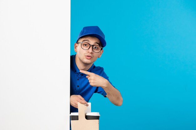 Vue de face du courrier masculin en uniforme bleu avec du café sur le bleu