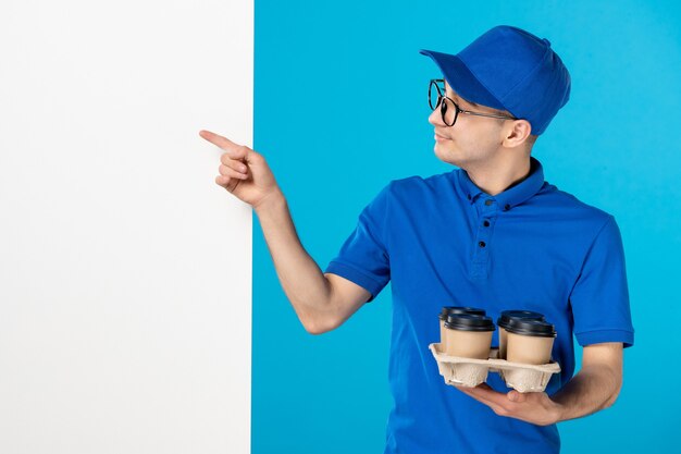 Vue de face du courrier masculin en uniforme avec du café sur bleu