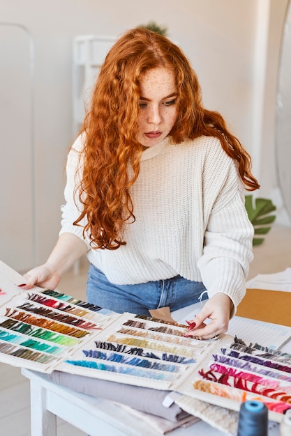 Vue de face du créateur de mode féminin travaillant en atelier avec palette de couleurs