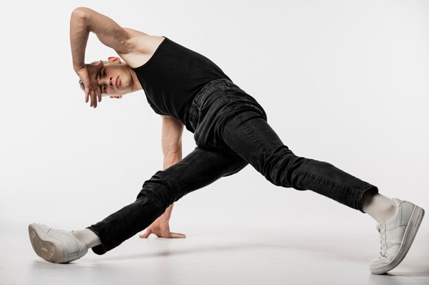 Vue de face du danseur en jeans et débardeur danse