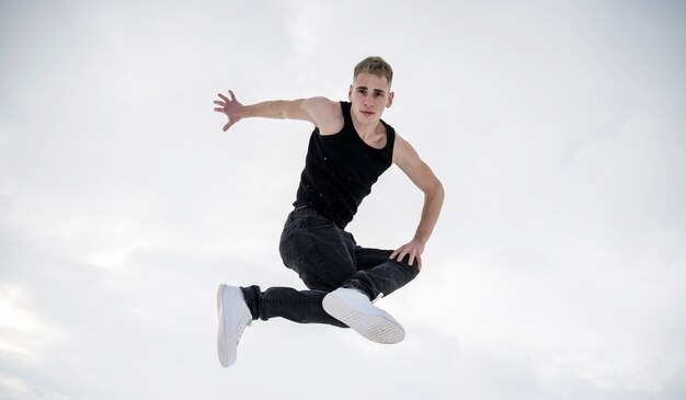 Vue de face du danseur posant dans les airs