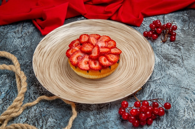 Vue de face du délicieux gâteau aux fraises aux fruits rouges sur une surface sombre