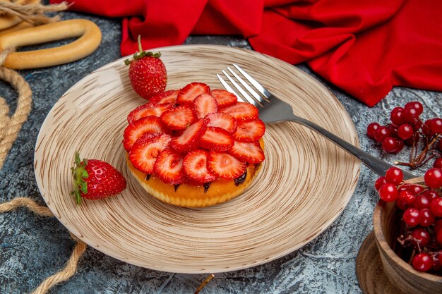 Vue de face du délicieux gâteau aux fraises avec des baies sur une surface sombre