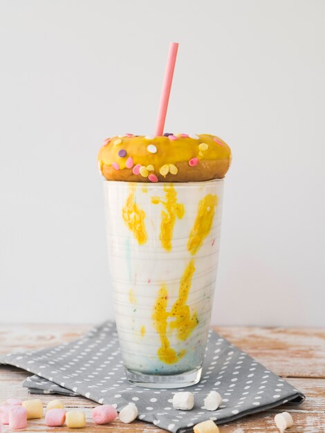 Vue de face du délicieux verre de milkshake sur une table en bois