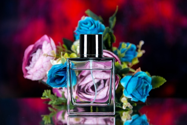 Photo gratuite vue de face du flacon de parfum rectangle fleurs colorées sur résumé rouge foncé