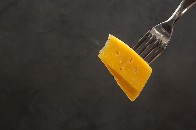 Vue de face du fromage frais en tranches sur une fourchette collation sombre repas photo couleur chips de petit-déjeuner