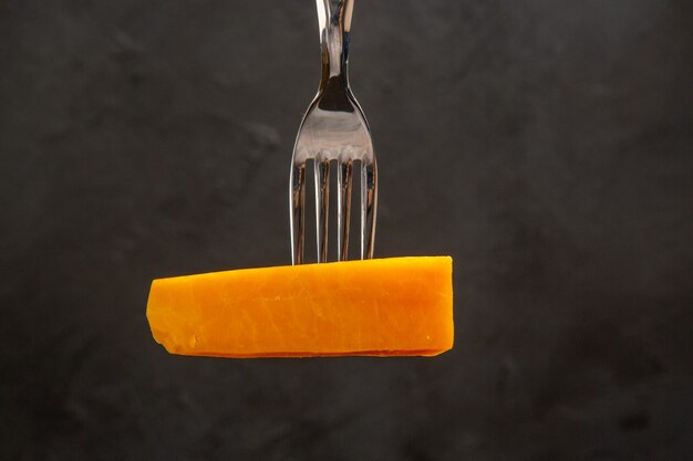 Vue de face du fromage en tranches sur une fourchette sur un repas sombre photo couleur petit-déjeuner croustillant