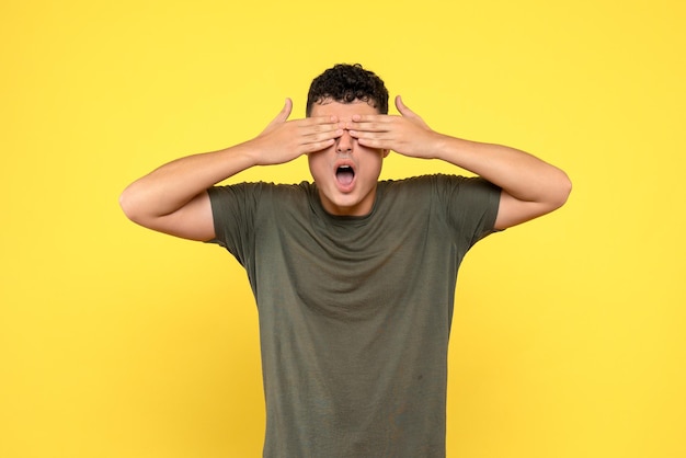 La vue de face du gars a couvert son visage avec ses mains et a ouvert la bouche