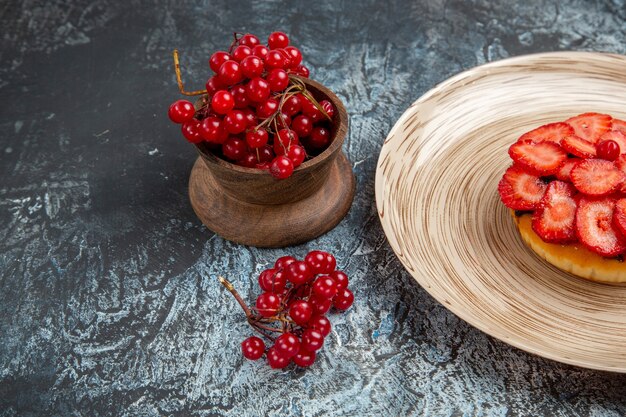 Vue de face du gâteau fruité avec des baies sur une surface sombre