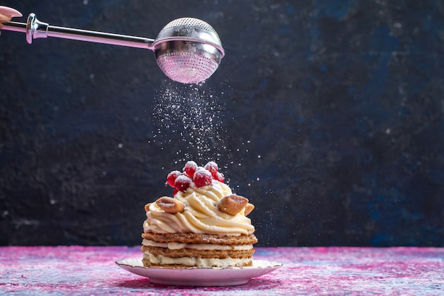 Vue de face du gâteau gaufré à la crème aux canneberges sur la surface sombre