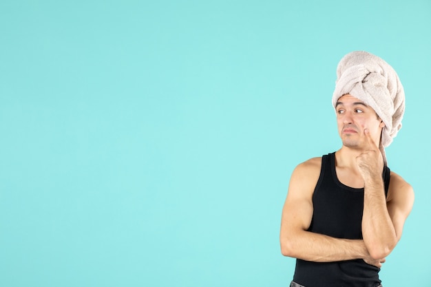 vue de face du jeune homme après la douche sur le mur bleu