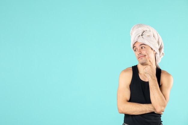 vue de face du jeune homme après la douche sur le mur bleu