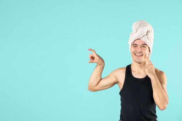 vue de face du jeune homme après la douche sur le mur bleu