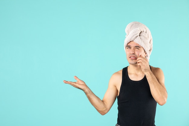 vue de face du jeune homme après la douche sur le mur bleu