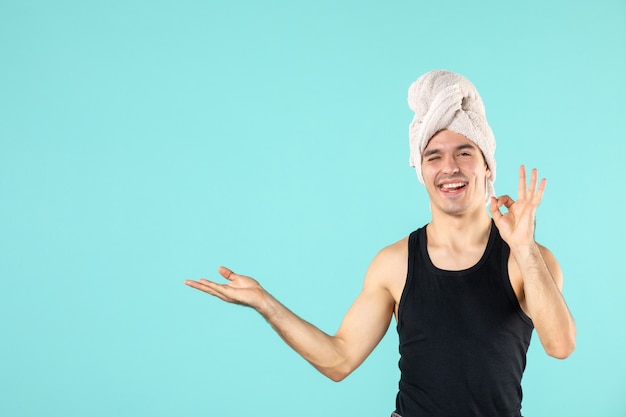 vue de face du jeune homme après la douche sur le mur bleu