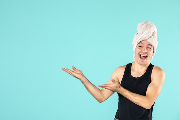 vue de face du jeune homme après la douche sur le mur bleu