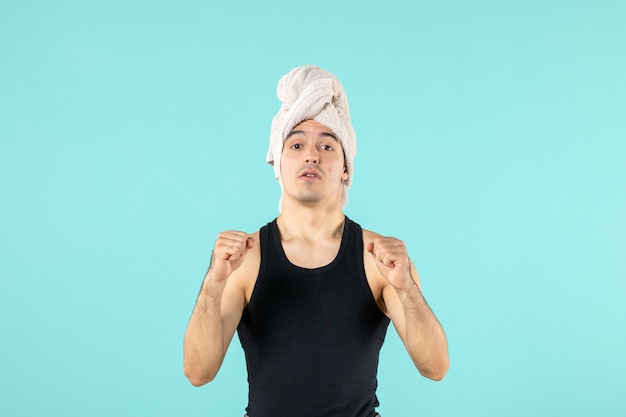 vue de face du jeune homme après la douche sur le mur bleu