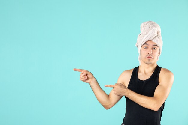 vue de face du jeune homme après la douche sur le mur bleu