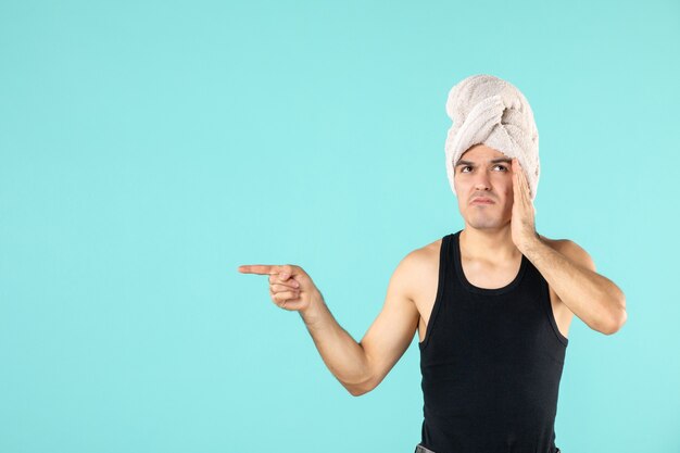 vue de face du jeune homme après la douche sur le mur bleu