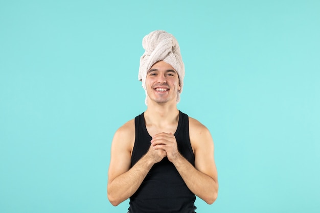 Photo gratuite vue de face du jeune homme après la douche souriant sur le mur bleu