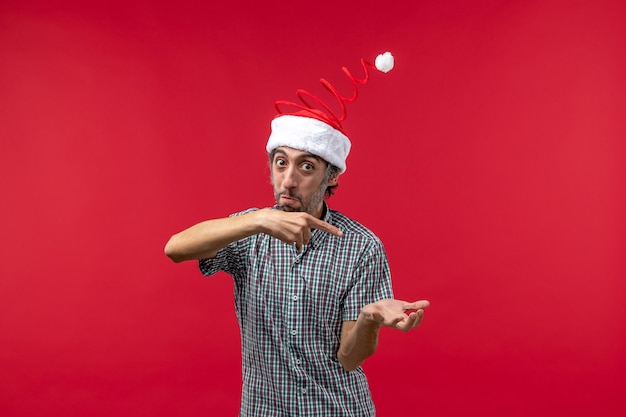 Photo gratuite vue de face du jeune homme avec une expression excitée sur le mur rouge