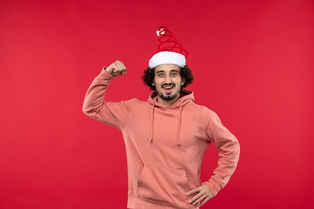 Vue de face du jeune homme avec une expression excitée sur le mur rouge