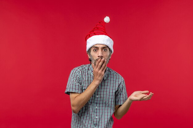 Photo gratuite vue de face du jeune homme avec une expression inquiète sur le mur rouge