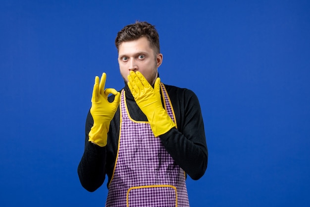 Vue De Face Du Jeune Homme Mettant La Main Sur Sa Bouche Faisant Signe Okey Sur Mur Bleu