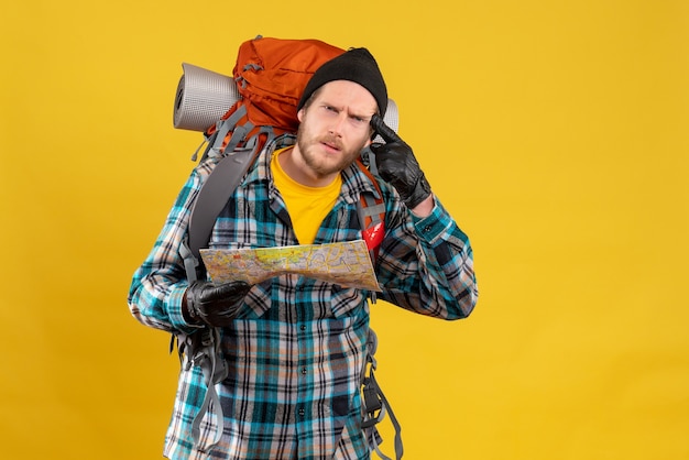 Photo gratuite vue de face du jeune touriste déconcerté avec des gants en cuir et sac à dos tenant la carte