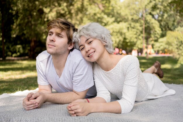 Vue de face du joli couple à l'extérieur sur une couverture