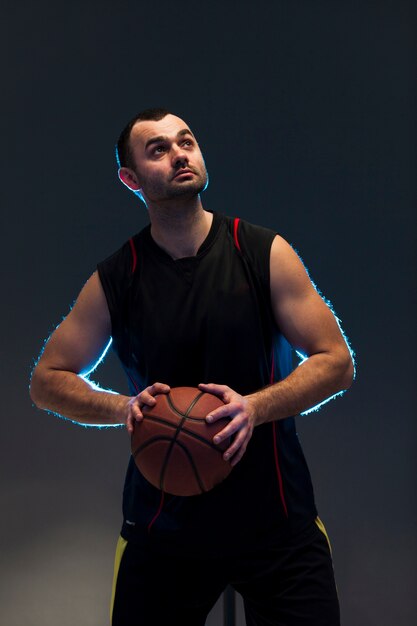 Vue de face du joueur de basket-ball tenant le ballon avec les deux mains