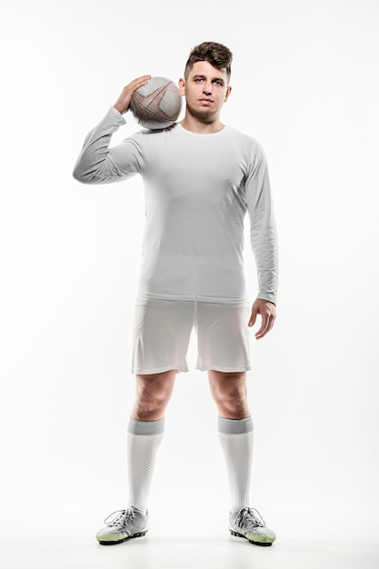 Vue de face du joueur de rugby masculin posant avec ballon