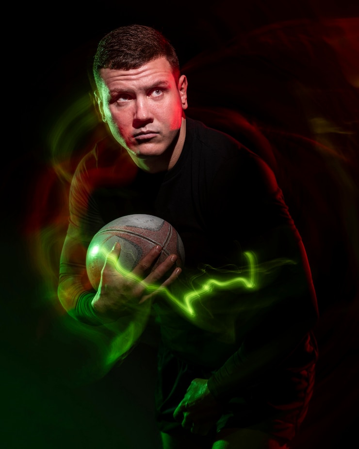 Photo gratuit vue de face du joueur de rugby masculin tenant le ballon avec effet de couleur