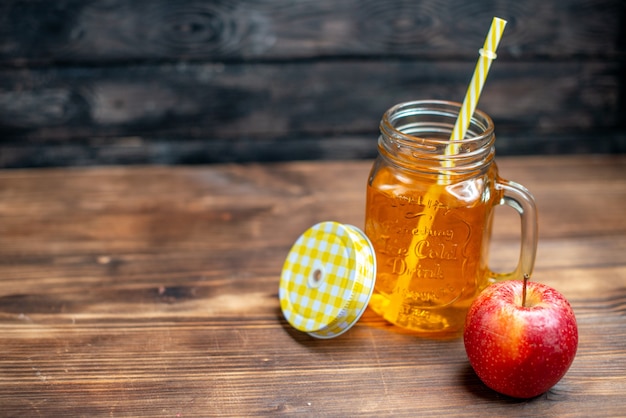 Vue de face du jus de pomme frais à l'intérieur de la boîte avec des pommes fraîches sur un bar noir, une boisson aux fruits, une couleur de cocktail