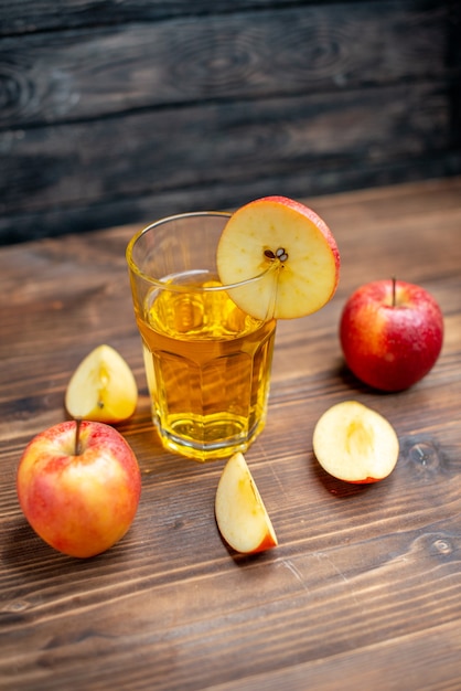 Vue de face du jus de pomme frais avec des pommes fraîches sur une boisson aux fruits cocktail de couleur sombre