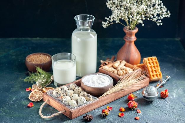 Photo gratuite vue de face du lait frais avec des œufs de biscuits et des noix sur une pâte bleu foncé cuire au four gâteau biscuit tarte thé pain pâtisserie sucre