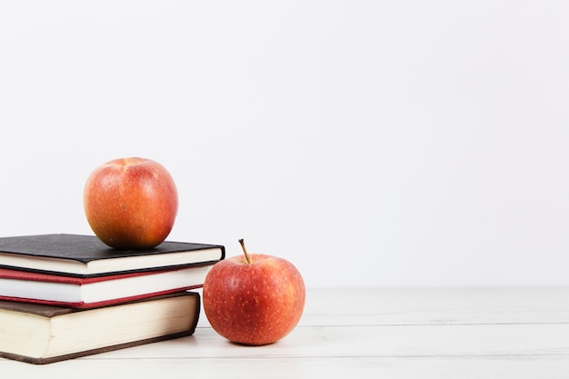 Photo gratuite vue de face du livre et des pommes