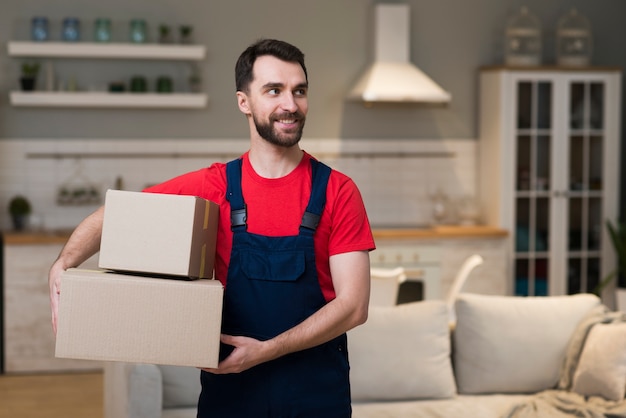 Vue de face du livreur tenant des boîtes