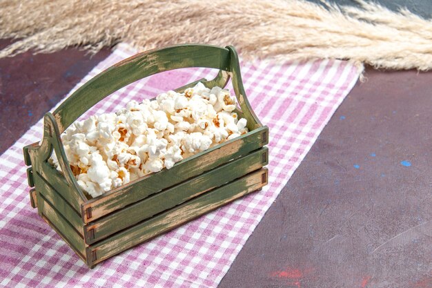 Photo gratuite vue de face du maïs soufflé frais à l'intérieur d'une boîte en bois sur du maïs soufflé à la surface sombre