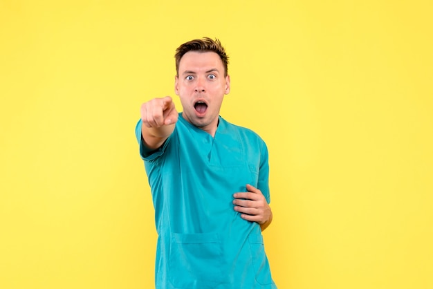 Vue de face du médecin avec une expression choquée sur le mur jaune