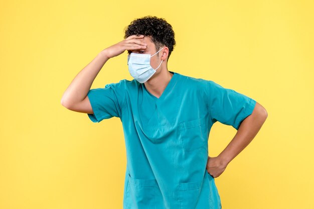 Vue de face du médecin le médecin en masque vous dit quel médicament vous pouvez prendre si vous avez mal à la tête