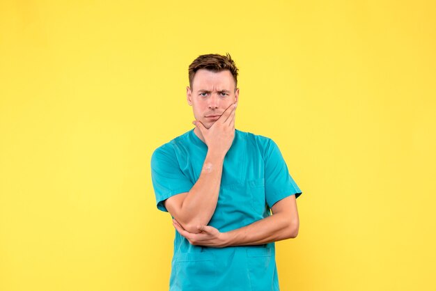 Vue De Face Du Médecin De Sexe Masculin Avec Une Expression Stressée Sur Mur Jaune