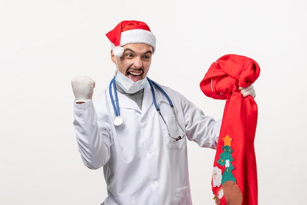 Vue De Face Du Médecin De Sexe Masculin Se Réjouissant Sur Le Mur Blanc